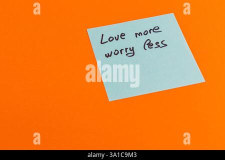 Un rappel motivant encourage à embrasser l'amour et à réduire les soucis. La note comporte du texte manuscrit dans un style décontracté, mis contre un OR vibrant Banque D'Images