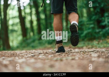 Gros plan vue arrière des jambes touristiques qui est dans la forêt d'été. Banque D'Images