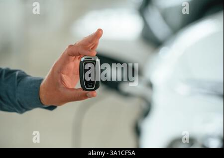 Vue rapprochée de l'homme qui est avec la voiture électrique. Banque D'Images