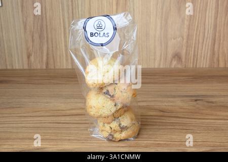 Un sac de biscuits avec une étiquette blanche qui dit Bolas. Les biscuits sont dans un sac en plastique et sont assis sur une table en bois Banque D'Images