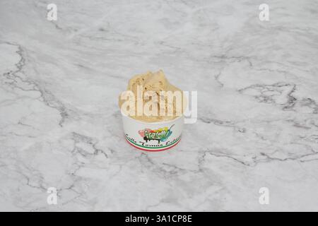 Une boule de crème glacée dans une tasse en papier. La crème glacée est brune et il est une boule de crème glacée à la vanille Banque D'Images