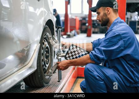 Prendre soin du disque de roue. Mécanicien automobile travaillant dans le garage. Service de réparation. Banque D'Images