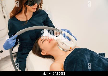 La femme reçoit le massage matériel LPG dans le salon de beauté. Procédure de photo-rajeunissement à la clinique de cosmétologie. Banque D'Images