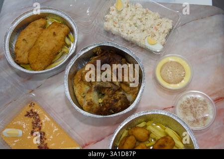 Une variété de nourriture est servie dans différents contenants, y compris un bol de purée de pommes de terre et une assiette de poulet Banque D'Images