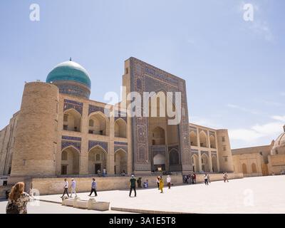Boukhara, Ouzbékistan - 09 juillet 2024 : vue de la façade de la Madrassa et la place avec des touristes à Boukhara Banque D'Images