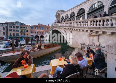 Venise, Italie - 12 octobre 2024 : les gens apprécient Aperol Spritz dans un café au bord de l'eau près du pont du Rialto Banque D'Images