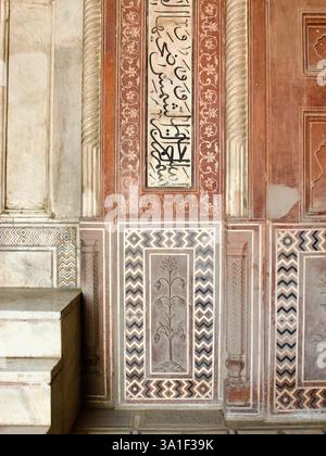 Détail de la calligraphie coranique, panneau floral et incrustation de chevron sur le mur de grès rouge à côté du Minbar dans la mosquée Taj Mahal, Agra. Banque D'Images