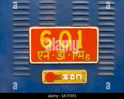 Gros plan d'une plaque d'identification d'une locomotive sur un train de Darjeeling Himalayan Railway, avec des lettres en hindi et en anglais. Banque D'Images