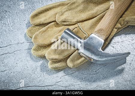 Gants de sécurité en cuir marteau à griffes sur fond métallique concept de construction Banque D'Images