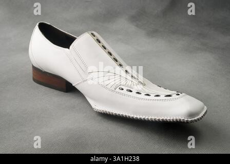 Chaussures en cuir blanc sur fond gris MR Banque D'Images