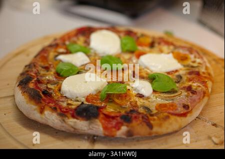Pizza maison sur la planche à découper en bois Banque D'Images