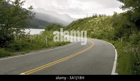 Les courbes lisses montrant des lignes blanches et jaunes sur la route de juneau alaska, U.S.A États-Unis d'Amérique Banque D'Images