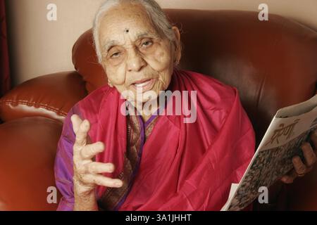 Une femme maharashtrienne de 92 ans lisant le journal, Inde MR#686J. Banque D'Images