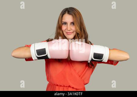 Portrait studio d'une jeune femme portant des gants de boxe roses, transmettant confiance et force Banque D'Images