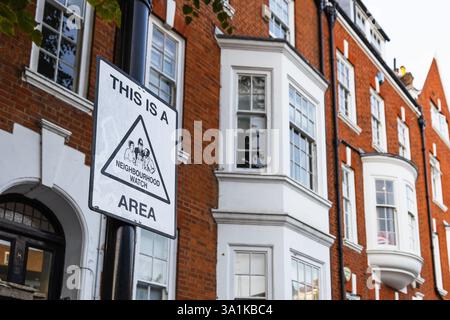 Quartier Watch Area Sign sur un poteau encadré par les élégantes maisons de brique de Londres Banque D'Images