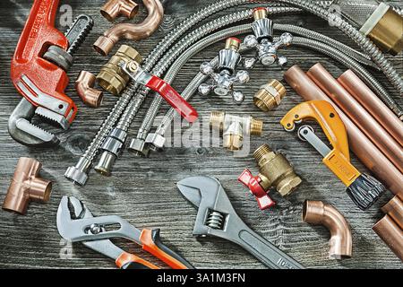 Concept de plomberie grand ensemble d'accessoires de tuyauterie singe et clés réglables à plomb raccords en cuivre coupe-tuyau en laiton sur fond de bois vintage Banque D'Images