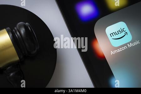 Gros plan sur l'écran d'un iPad affichant l'application amazon Music à côté du marteau d'un juge Banque D'Images
