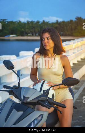 Touriste appréciant une balade panoramique en moto au crépuscule sur le pont afam, en profitant de la vue imprenable sur le paysage tropical de l'île de Siargao Banque D'Images