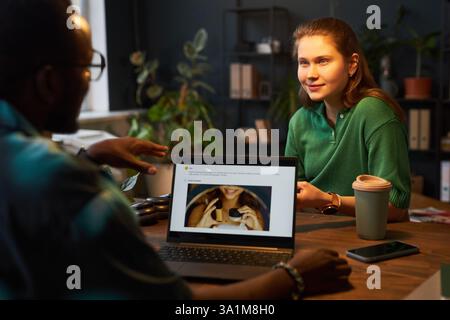 Jeune femme parlant à son collègue au bureau Banque D'Images