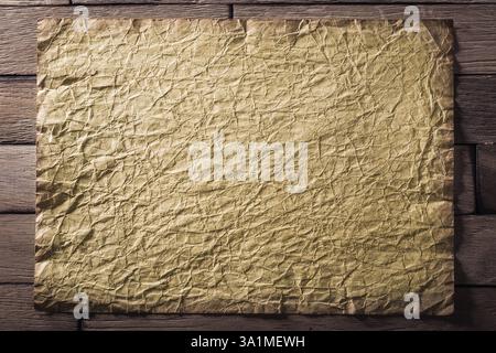 Vieille feuille de papier froissée sur des planches de bois. CR2 Banque D'Images