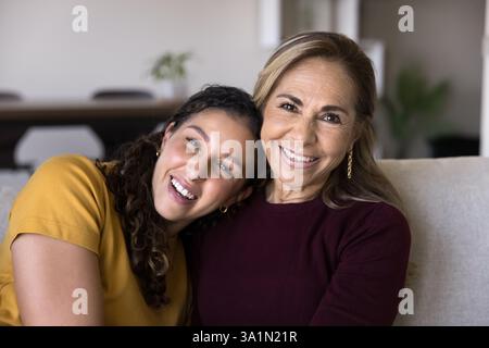Jeune fille adulte posant pour la caméra avec une mère plus âgée Banque D'Images