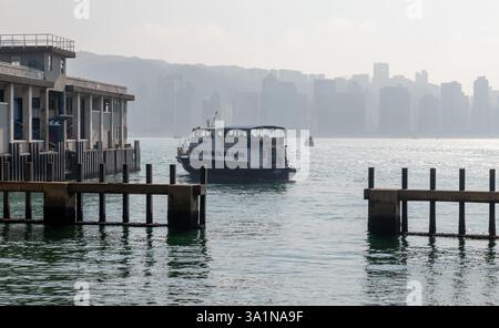 Hong Kong. Chine- 02.15.2025. Le Kwun Tong Ferry Pier à East Kowloon avec un ferry partant pour l'île de Hong Kong. Banque D'Images