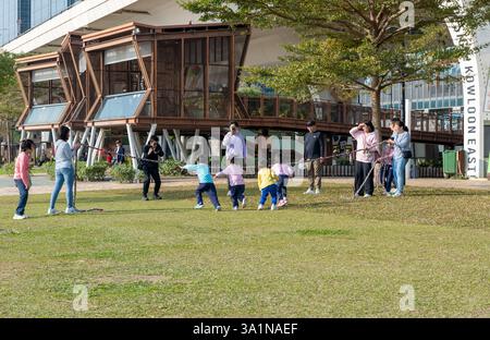 Hong Kong. Chine- 02.15.2025. Les parents et les enfants profitent d'une chaude journée ensoleillée avec du plaisir et des jeux sur la promenade de Kwun Tong. Banque D'Images