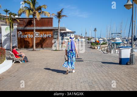 Les gens apprécient le soleil d'hiver de février dans les bars et cafés le long du port de la station balnéaire des Canaries de Puerto Calero Lanzarote Espagne Banque D'Images