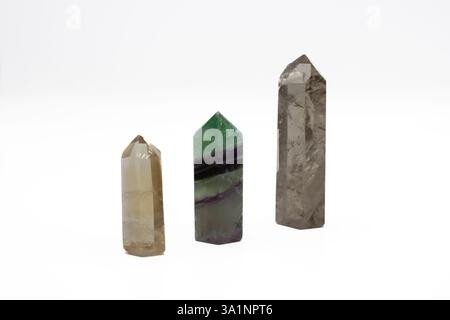 2 cristaux de quartz fumés et baguets de cristal de fluorite sur fond blanc Banque D'Images