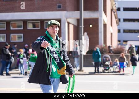 Scranton, PA - 8 mars 2025 : pendant la défilé de Patrick, les gens marchent et distribuent des bonbons et des souvenirs. Banque D'Images