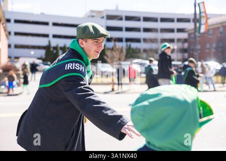 Scranton, PA - 8 mars 2025 : pendant la défilé de Patrick, les gens marchent et distribuent des bonbons et des souvenirs. Banque D'Images