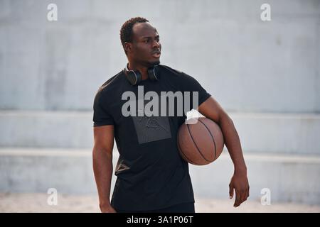 Tenir le ballon dans les mains. Jeune homme noir. Banque D'Images