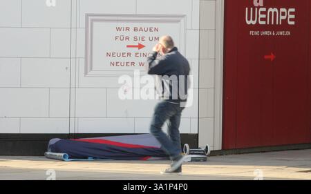 Ein Obdachloser liegt in seinem Schlafsack vor dem Juwelier Wempe am Jungfernstieg, der gerade umgebaut wird. Ein passant geht an dem schlafenden Mann vorbei. Altstadt Hamburg *** Un sans-abri est allongé dans son sac de couchage en face de la bijouterie Wempe sur Jungfernstieg, qui est en cours de rénovation Un passant passe devant la vieille ville de Hambourg Sleeping Man Banque D'Images