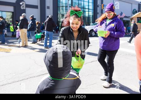 Scranton, PA - 8 mars 2025 : pendant la défilé de Patrick, les gens marchent et distribuent des bonbons et des souvenirs. Banque D'Images
