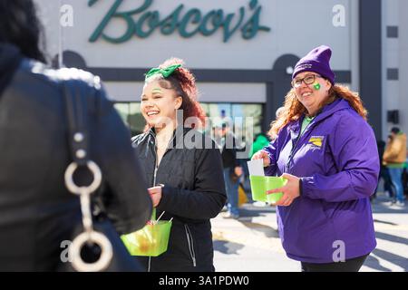 Scranton, PA - 8 mars 2025 : pendant la défilé de Patrick, les gens marchent et distribuent des bonbons et des souvenirs. Banque D'Images