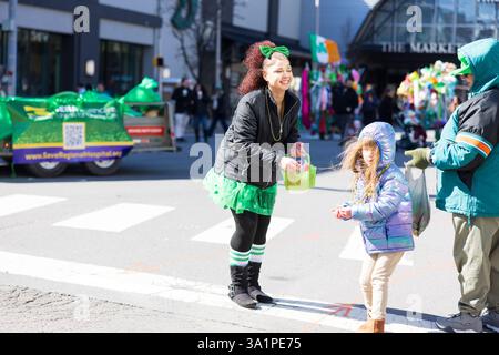 Scranton, PA - 8 mars 2025 : pendant la défilé de Patrick, les gens marchent et distribuent des bonbons et des souvenirs. Banque D'Images