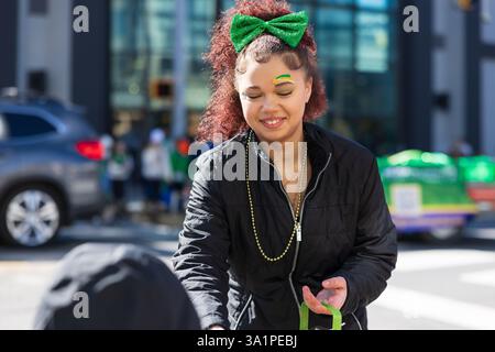 Scranton, PA - 8 mars 2025 : pendant la défilé de Patrick, les gens marchent et distribuent des bonbons et des souvenirs. Banque D'Images