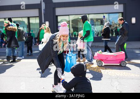 Scranton, PA - 8 mars 2025 : pendant la défilé de Patrick, les gens marchent et distribuent des bonbons et des souvenirs. Banque D'Images