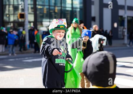 Scranton, PA - 8 mars 2025 : pendant la défilé de Patrick, les gens marchent et distribuent des bonbons et des souvenirs. Banque D'Images