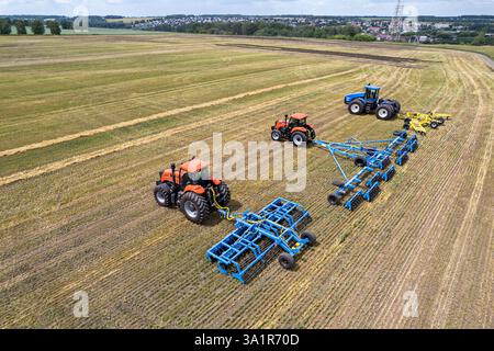 Une grande machine agricole cultive la terre. La vue du dessus. Labourage de terres pour la plantation de cultures. Photos de la vue de l'oiseau avec un quadc Banque D'Images