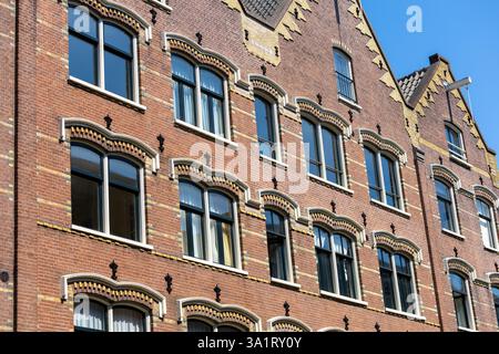 Façades de bâtiments à Amsterdam, maisons historiques en briques de canal dans une rangée. Banque D'Images
