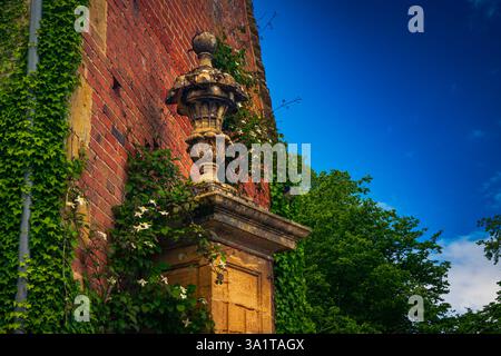 Une statue au sommet de la porte d'entrée d'un manoir dans les Cotswolds, Gloucestershire, Royaume-Uni Banque D'Images