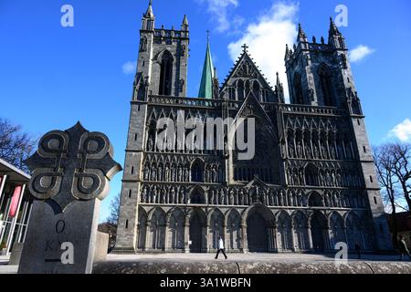 Trondheim, Norvège. 10 mars 2025. Le soleil baigne la façade ouest de la cathédrale de Nidaros à Trondheim dans la lumière et l'ombre. La façade à caissons montre 57 statues et histoires de l'ancien Testament. Le bâtiment sacré est l'une des églises les plus importantes de Norvège. Après des journées pluvieuses avec des températures douces, la semaine dans la troisième plus grande ville de Norvège commence avec beaucoup de soleil. Crédit : Hendrik Schmidt/dpa/Alamy Live News Banque D'Images