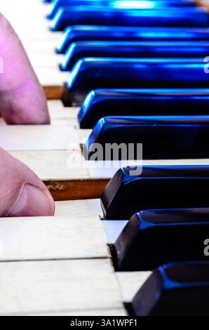 Les deux doigts de l'homme représentés jouant les touches ivoire du piano Antique s'éloignant dans l'arrière-plan Banque D'Images