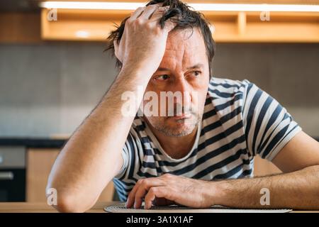 Triste regrettable homme déçu à la maison, concept de santé mentale et de dépression, focalisation sélective Banque D'Images