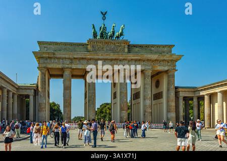 Touristes à Pariser Paltz sous la porte de Brandebourg. Cette porte monumentale du XVIIIe siècle est surmontée de statues de divinités classiques. Berlin, Allemagne Banque D'Images