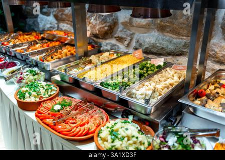 Les clients apprécieront un délicieux buffet rempli d'un éventail de salades fraîches, légumes rôtis et plats d'accompagnement savoureux, créant une atmosphère vibrante fo Banque D'Images