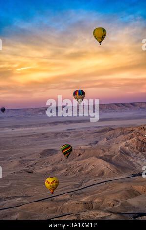 Montgolfières dans le ciel au-dessus de la Vallée des Reines sur la rive ouest de Louxor, Egypte. Banque D'Images