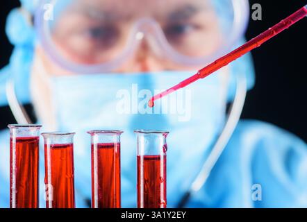 Test sanguin. Le docteur travaille avec l'échantillon de sang du patient en laboratoire. Goutte de sang sur pipette, foyer sélectif. Scientifique médical ou assistant de laboratoire analysant b Banque D'Images