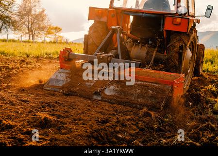 Tracteur semant les cultures dans les champs agricoles au printemps. Banque D'Images